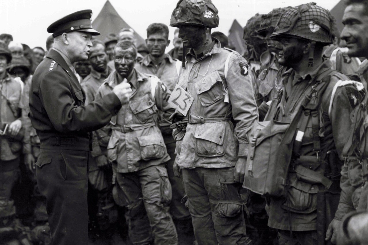 General Eisenhower talking to paratroopers, emphasizing the importance of full victory before they embark on their mission to Europe.