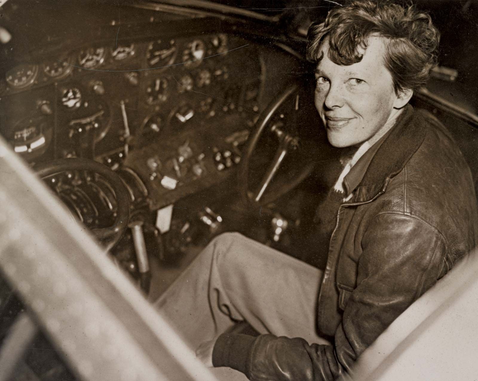 Amelia Earhart in the cockpit of her Lockheed Electra aircraft, preparing for her ill-fated world flight.