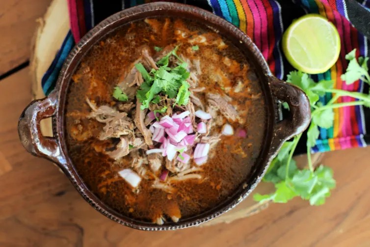 Barbacoa de borrego on a table with garnish