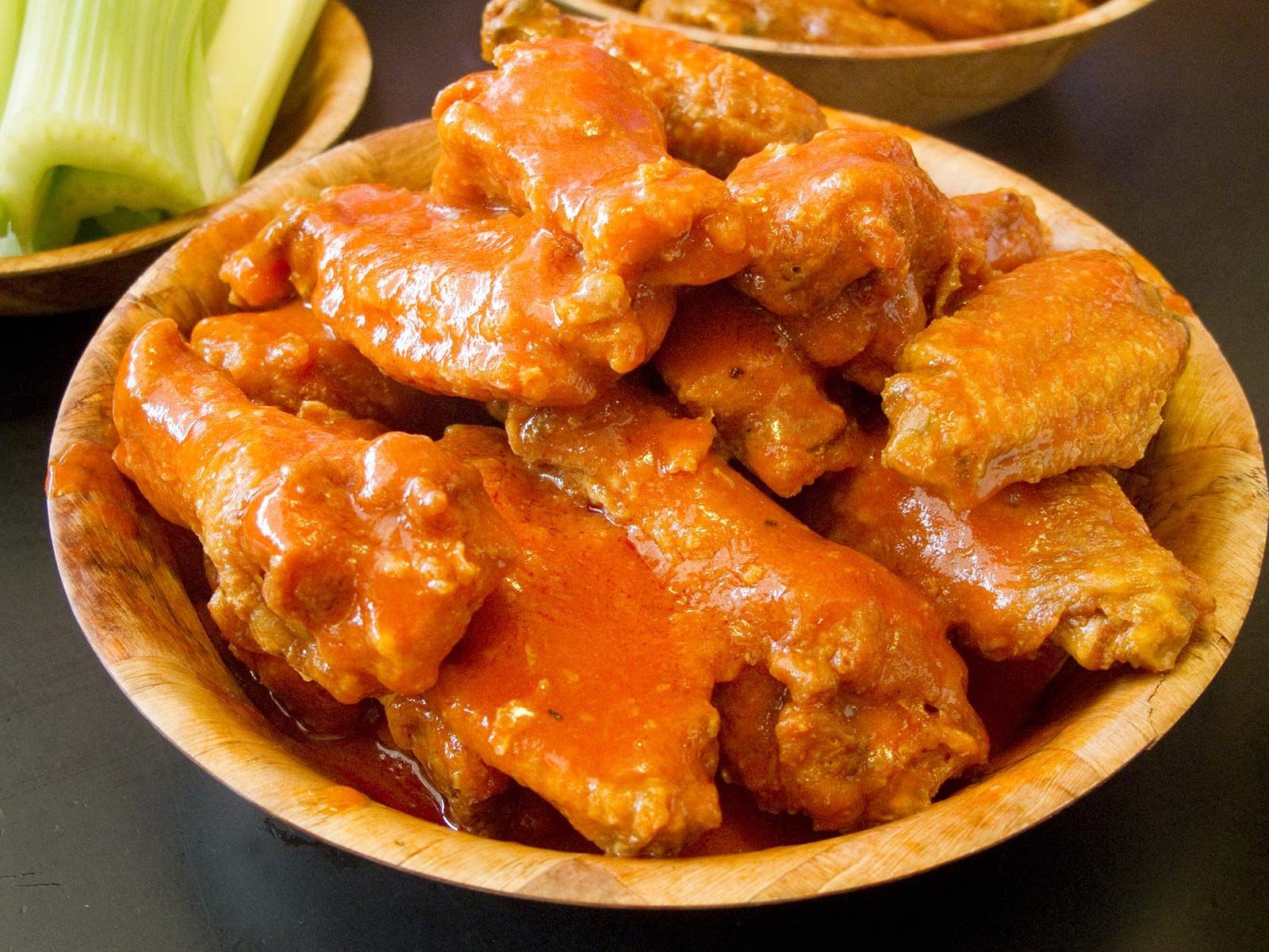 Buffalo wings coated in a vibrant vinegar-based hot sauce, illustrating vinegar's role in flavoring and marinades for meat products.