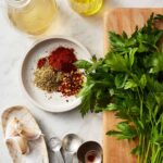 Close-up of chimichurri ingredients including fresh parsley, garlic, olive oil, and spices, highlighting the freshness and simplicity of the sauce.