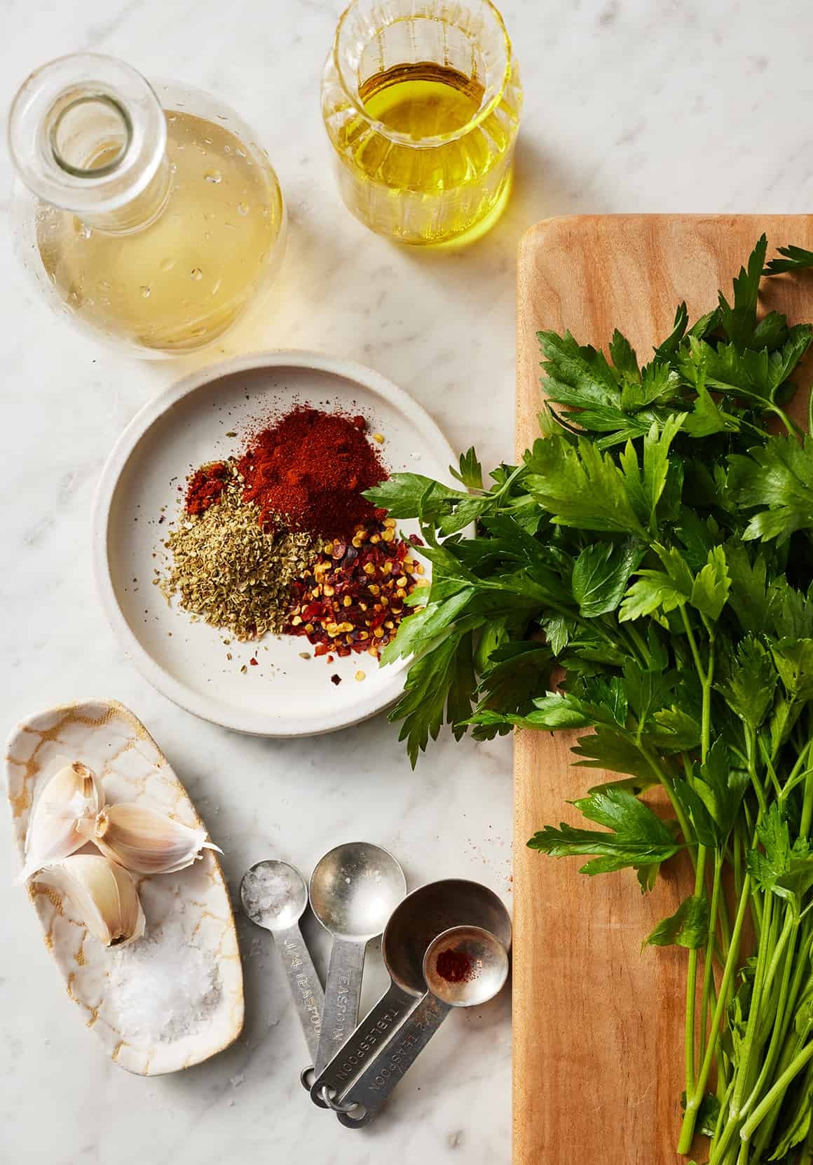 Close-up of chimichurri ingredients including fresh parsley, garlic, olive oil, and spices, highlighting the freshness and simplicity of the sauce.