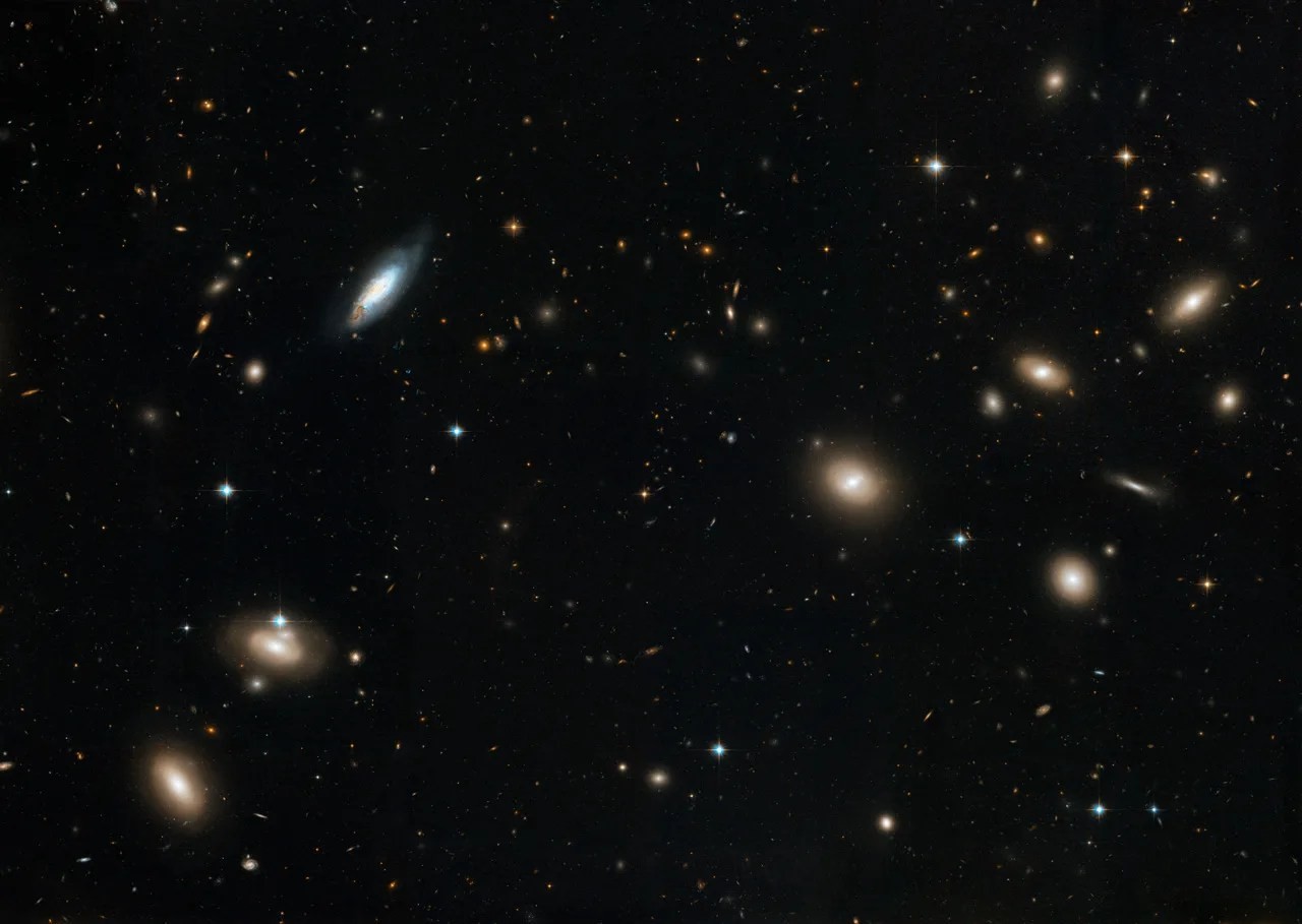 A stunning image of the Coma Cluster of galaxies, a rich collection of galaxies bound together by gravity, used as visual evidence for the existence of dark matter due to the observed motions of galaxies within the cluster exceeding what visible matter alone would predict.