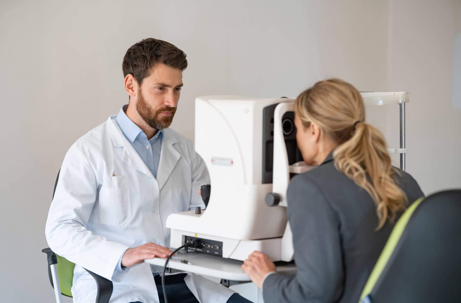 A doctor uses an ophthalmoscope to examine a patient's eye, checking for keratitis and other conditions misdiagnosed as pink eye.