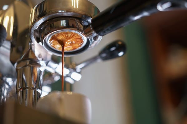 Espresso shot being pulled from a professional machine, highlighting the base ingredient of an Americano coffee.