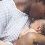 A loving African American mother bonding with her newborn baby, highlighting the role of oxytocin in maternal connection.