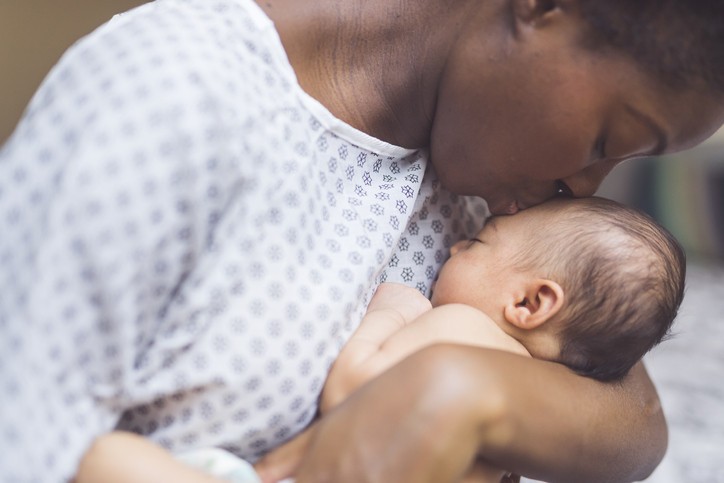 A loving African American mother bonding with her newborn baby, highlighting the role of oxytocin in maternal connection.