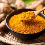 Close-up of turmeric powder and fresh turmeric root, highlighting curcumin's vibrant color and natural source