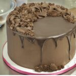 A decadent chocolate cake generously coated with smooth, dark chocolate ganache.