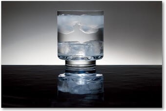 Glass of water with normal ice cubes floating and heavy ice cubes sinking, showcasing density differences