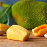 Close-up of vibrant yellow jackfruit, showcasing its size and textured skin, a large tropical fruit growing on a tree