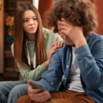 Upset couple sitting apart on couch looking in opposite directions