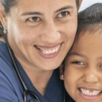 female nurse hugging a child. Qualities Should a CNA Possess