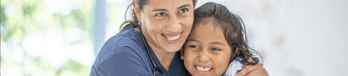 female nurse hugging a child. Qualities Should a CNA Possess