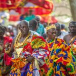 Leaders in brightly colored regalia and kente cloth process during the Odwira Festival in Ghana