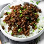 a photo of a bowl of steamed white rice topped with korean ground beef and sliced green onions