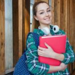 High school student in hallway with binder