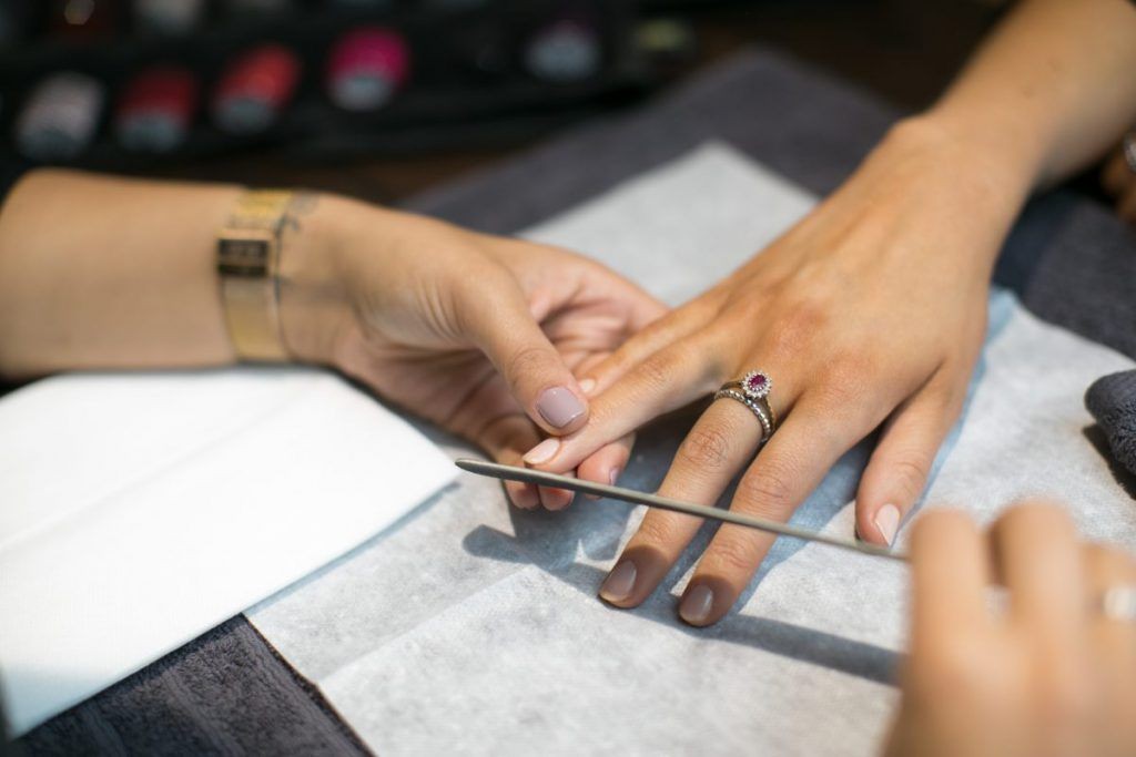 Woman getting her nails filed during a manicure