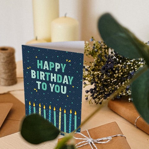Blue and green birthday card featuring colourful candle illustrations