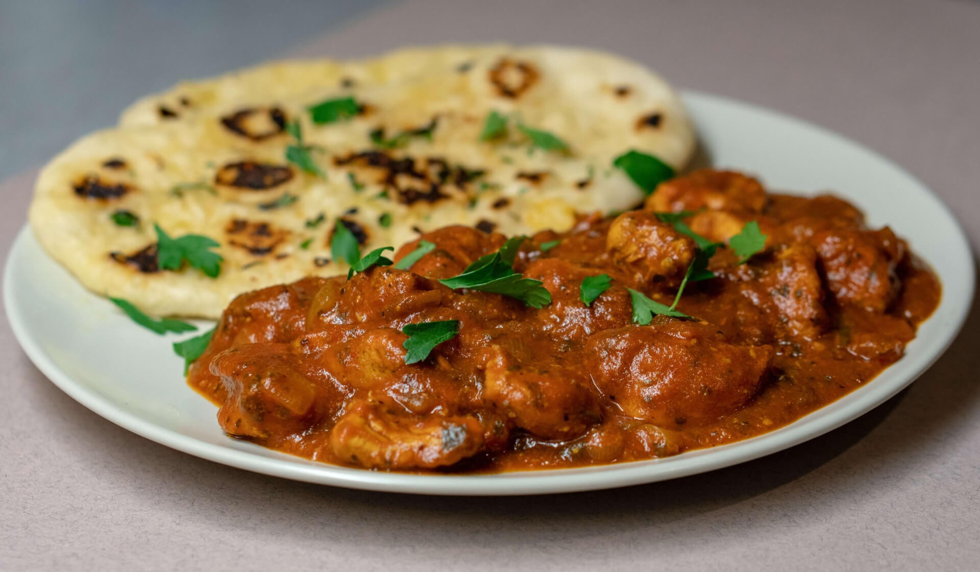 Indian chicken tikka masala with naan in a plate