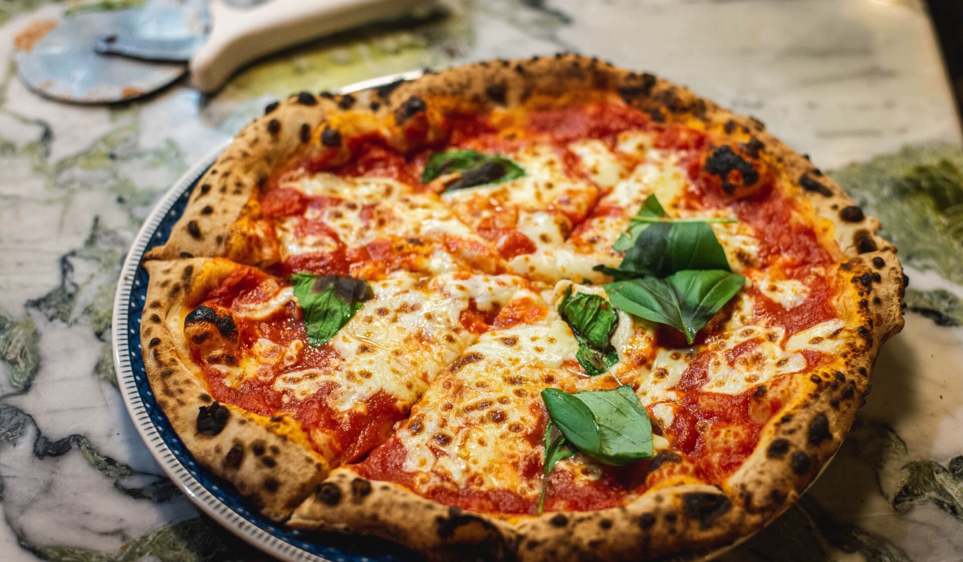 True Italian-style pizza with bubbly crust, lots of melted mozzarella, and fresh basil leaves