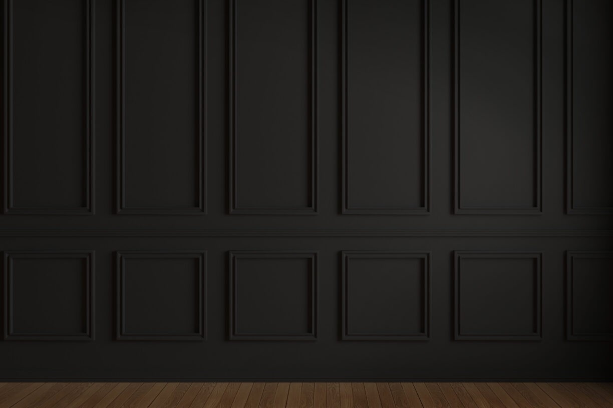 A photo featuring black walls adorned with vintage-style wainscoting, extending from floor to ceiling