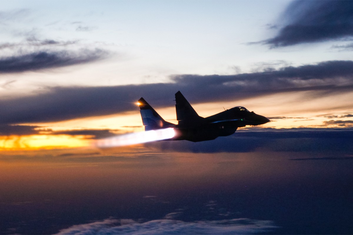 Fighter Jet plane silhouette against a sunset, capturing the essence of a Bangladesh Air Force MiG-29 with full afterburners engaged