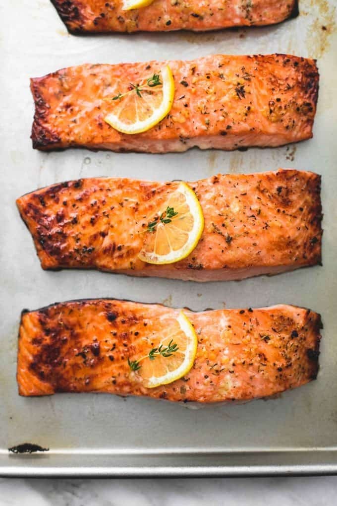 Baked salmon with a crispy crust and flaky interior, seasoned with herbs and spices.