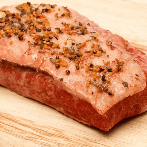 Close-up view of raw brisket with seasoning