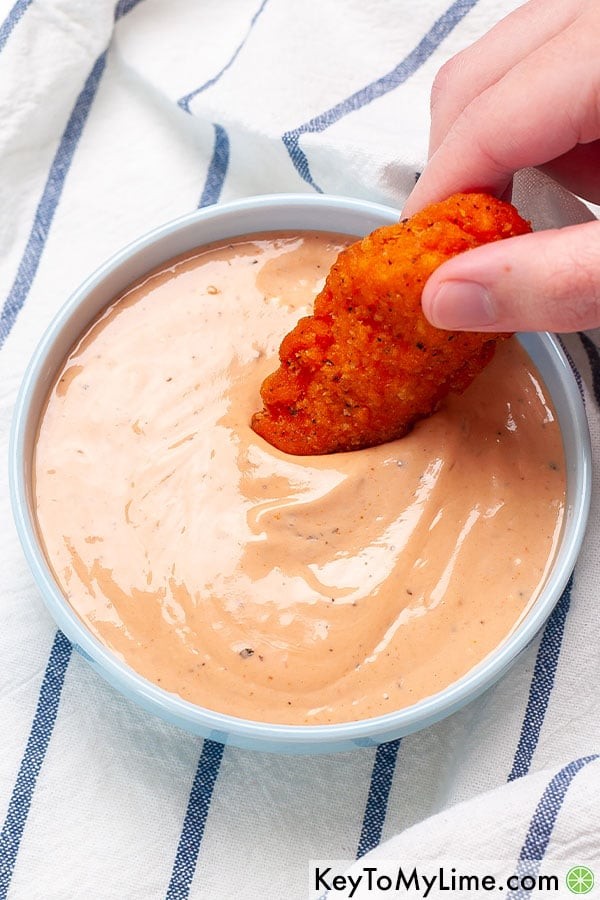 Dipping a chicken tender in an easy to make Cane