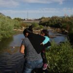 Woman crosses the Rio Grande with her child
