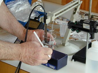 Measuring a water sample in a lab to determine alkalinity