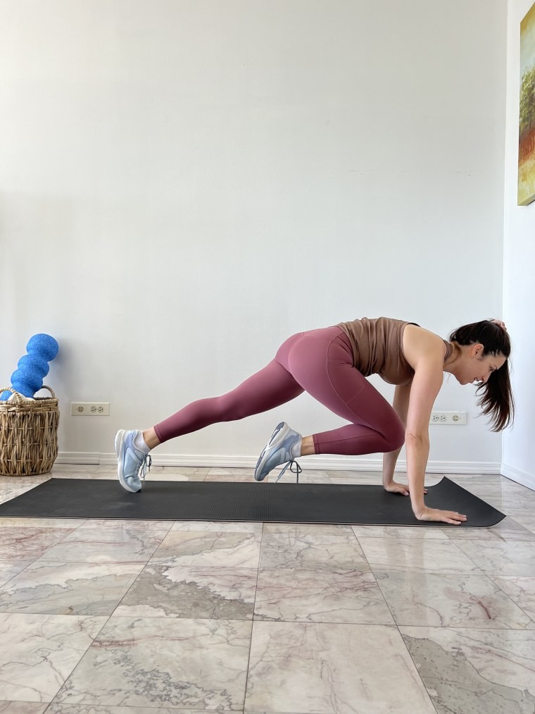 Woman doing a knee tuck into a pushup for Tabata