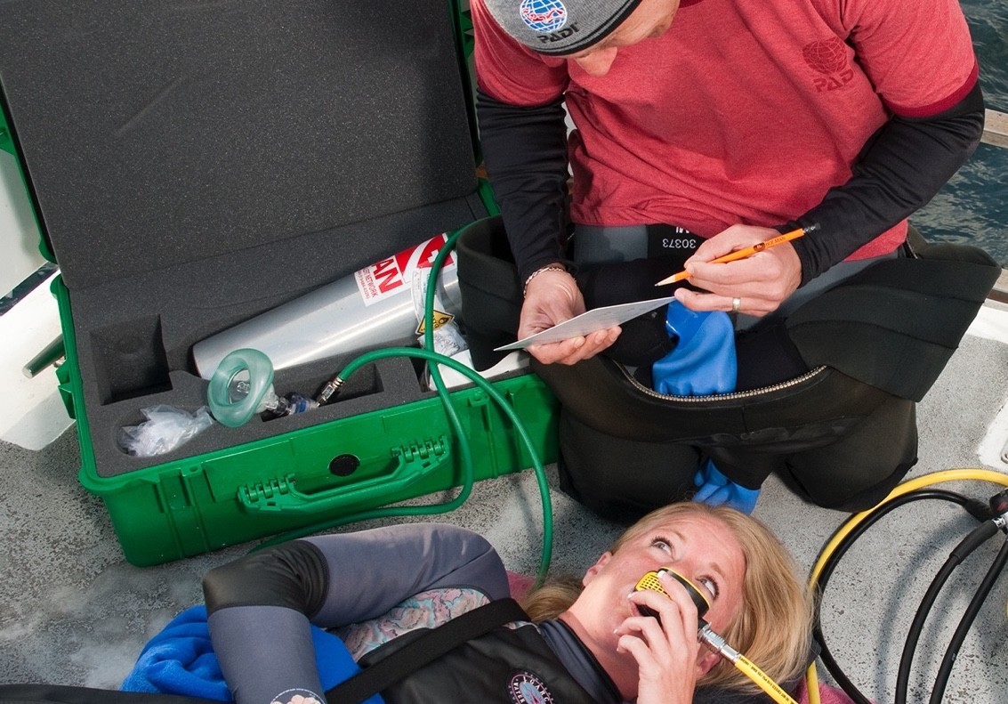 Diver administering emergency oxygen, which is crucial as a first step in treating decompression sickness