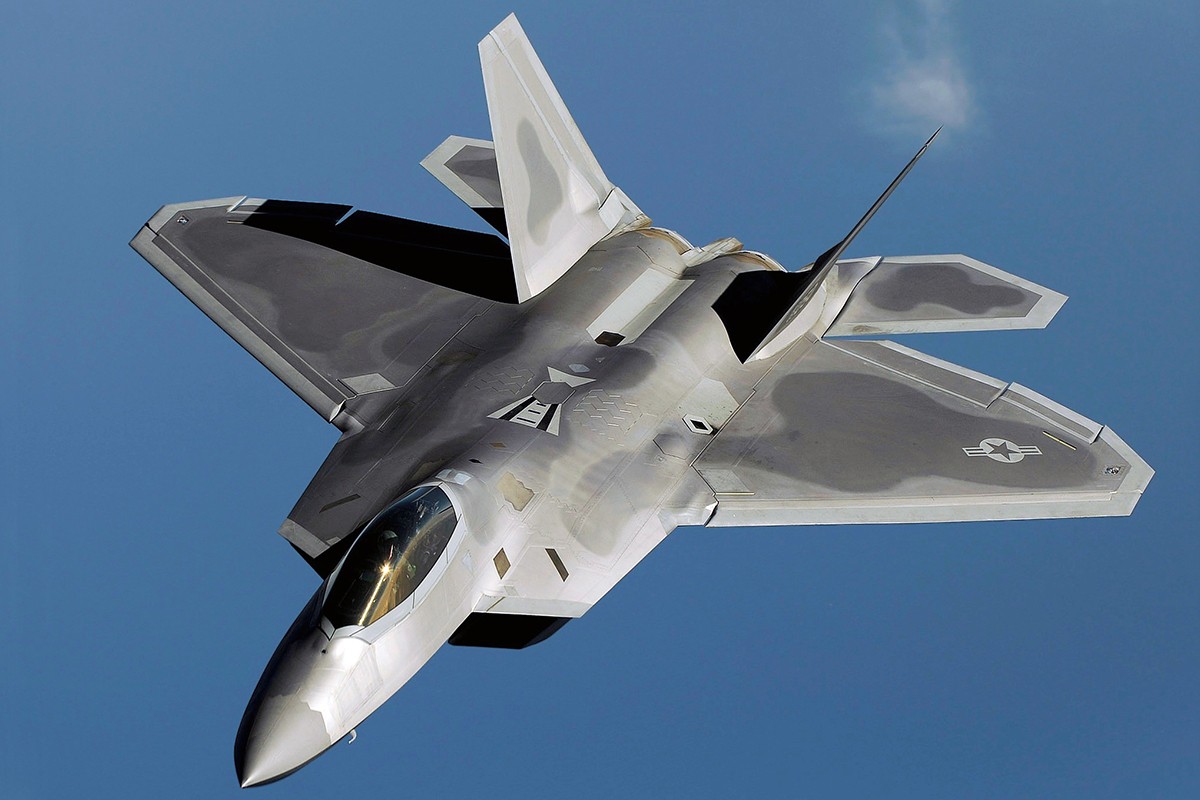 An F-22 Raptor flies over Kadena Air Base, Japan, on a routine training mission, highlighting its advanced stealth capabilities and air dominance potential