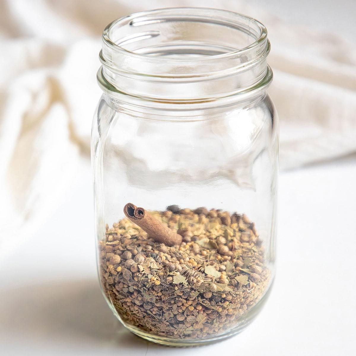 Ingredients for homemade pickling spice arranged on a wooden surface