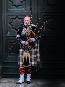 A bagpiper in traditional Scottish attire