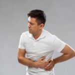 Man holding lower back in pain, signifying a potential kidney issue