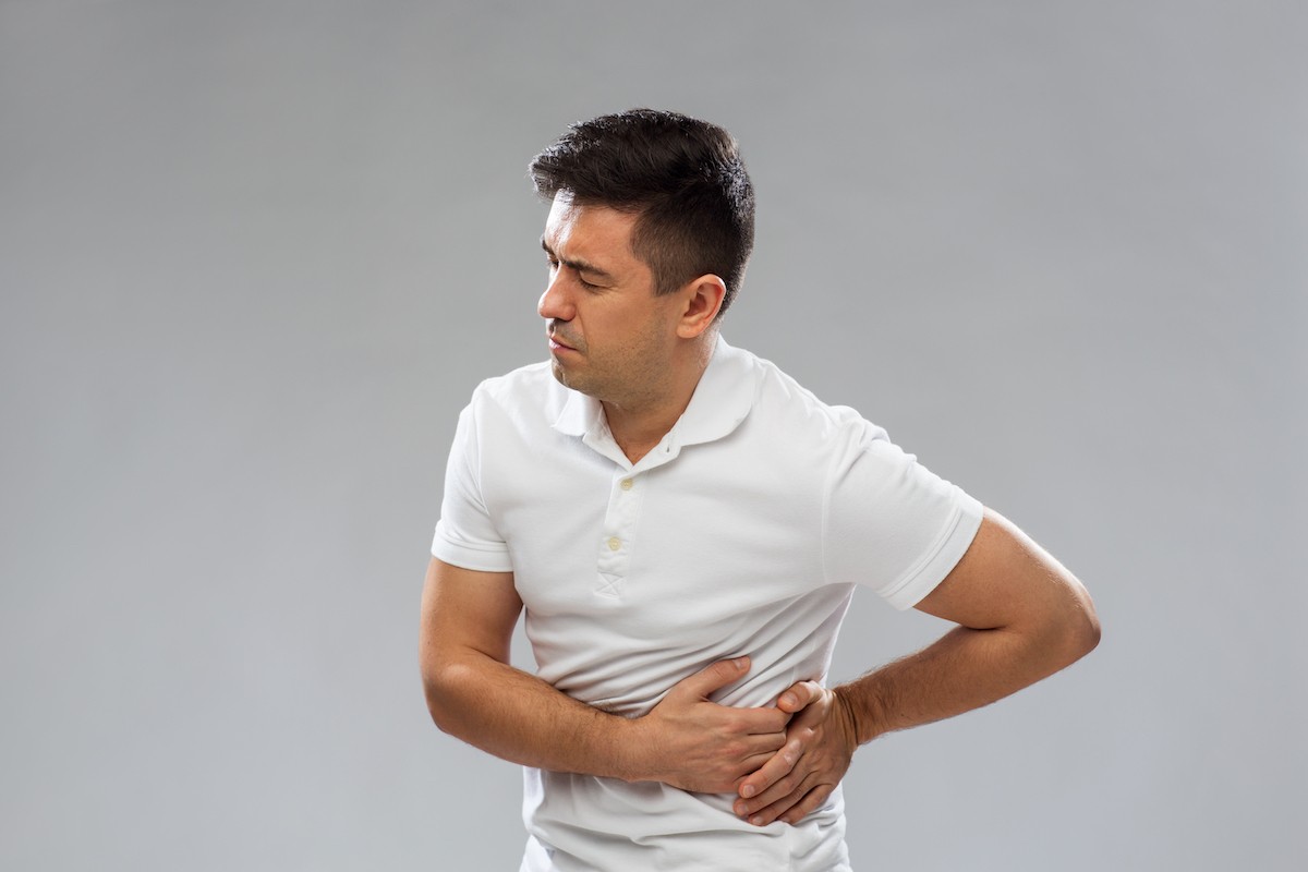 Man holding lower back in pain, signifying a potential kidney issue