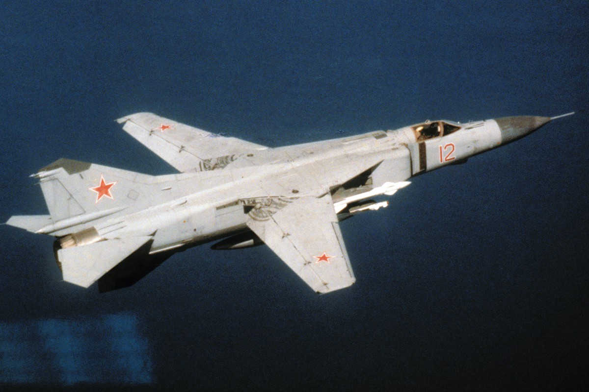 Airborne grey fighter jet, providing a clear view of a Soviet-era MiG-23 in flight, highlighting its design features and capabilities