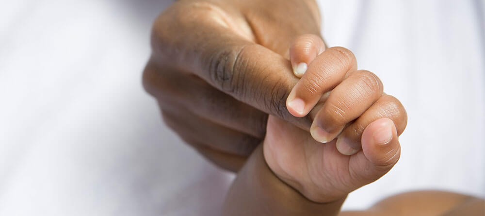 A medical professional in scrubs, possibly an OB/GYN, examining an ultrasound during a prenatal checkup, showcasing the care and attention involved in women's health.