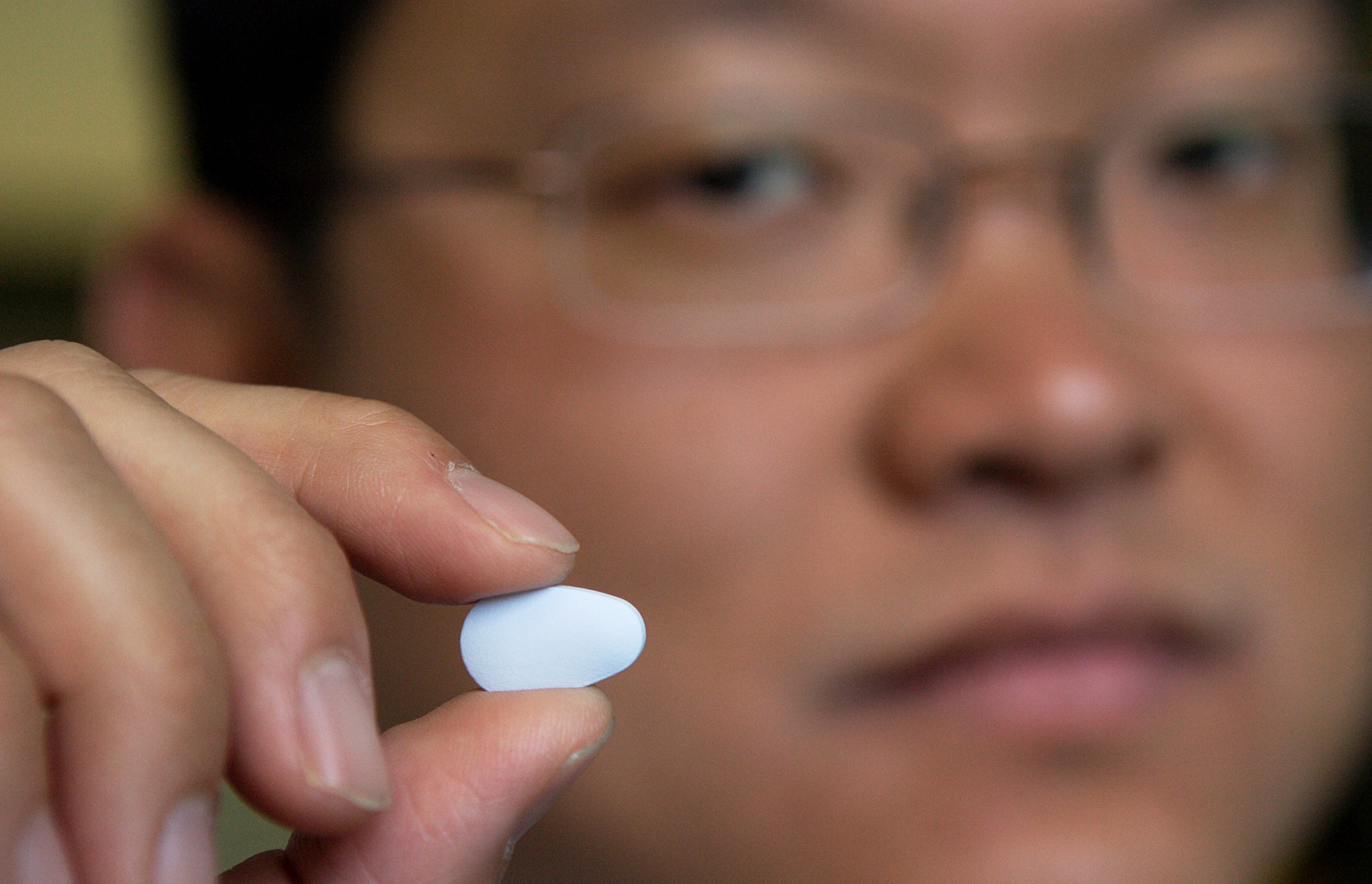 Dr. Albert Liu holding an antiretroviral pill