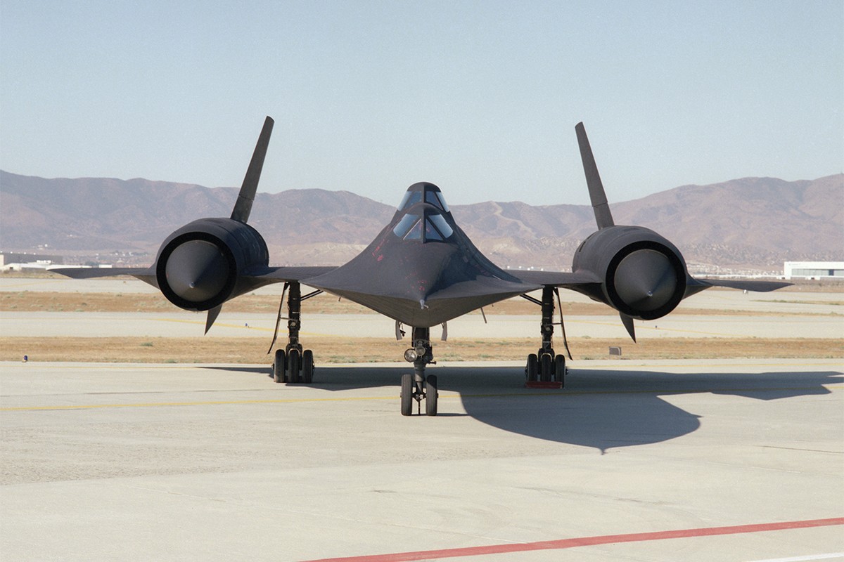 Stealth fighter jet sat on runway, showcasing the iconic design of Lockheed's SR-71B used for pilot training and proficiency at high speeds