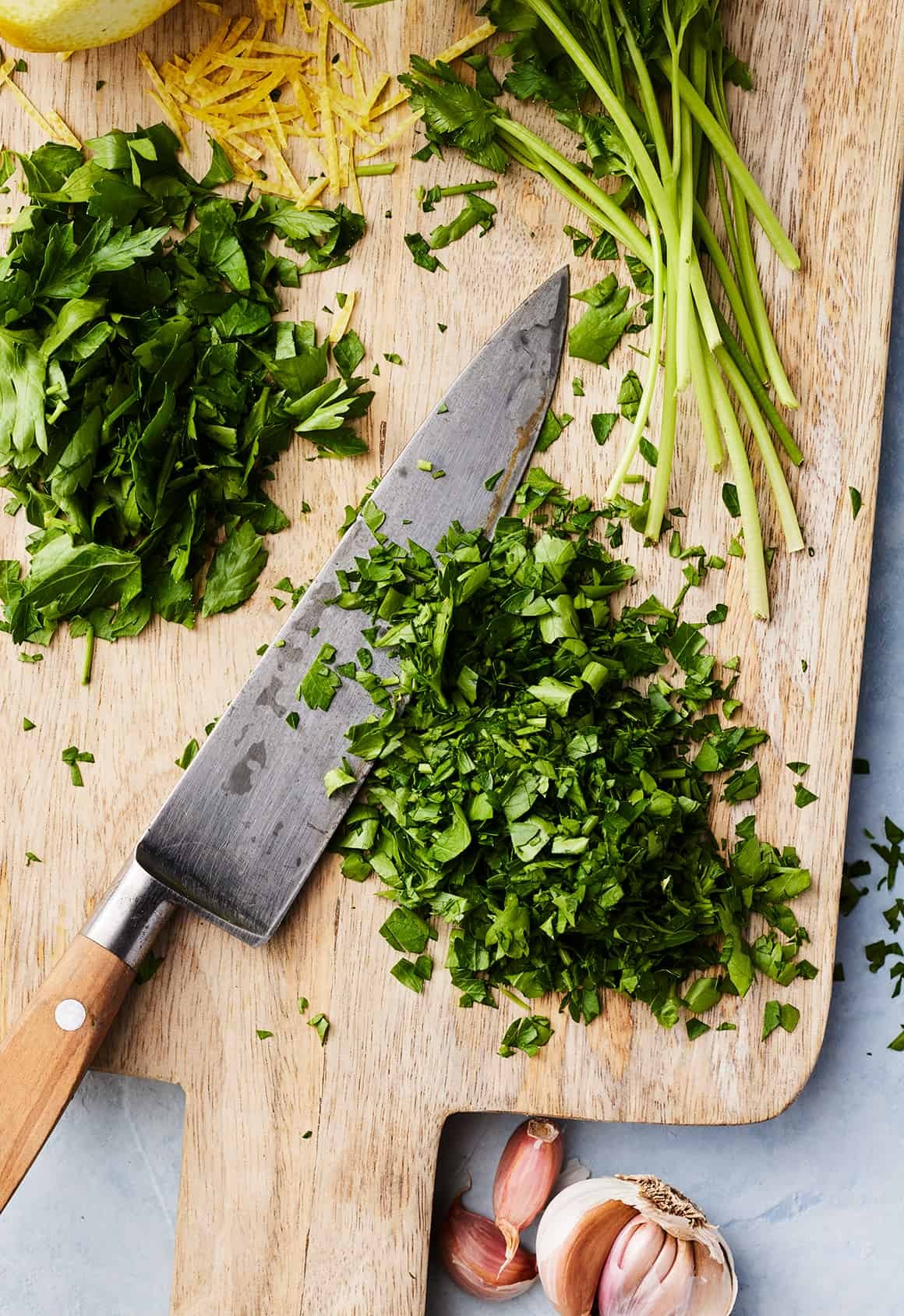Finely chopped fresh parsley on cutting board with chef