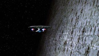 A large structure on the right is part of a Dyson sphere with the spaceship in the center of the screen heading in for a closer look.